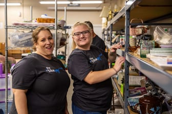 Blue & Co staff members from the Columbus office tidy up items on the shelves in Sans Souci 