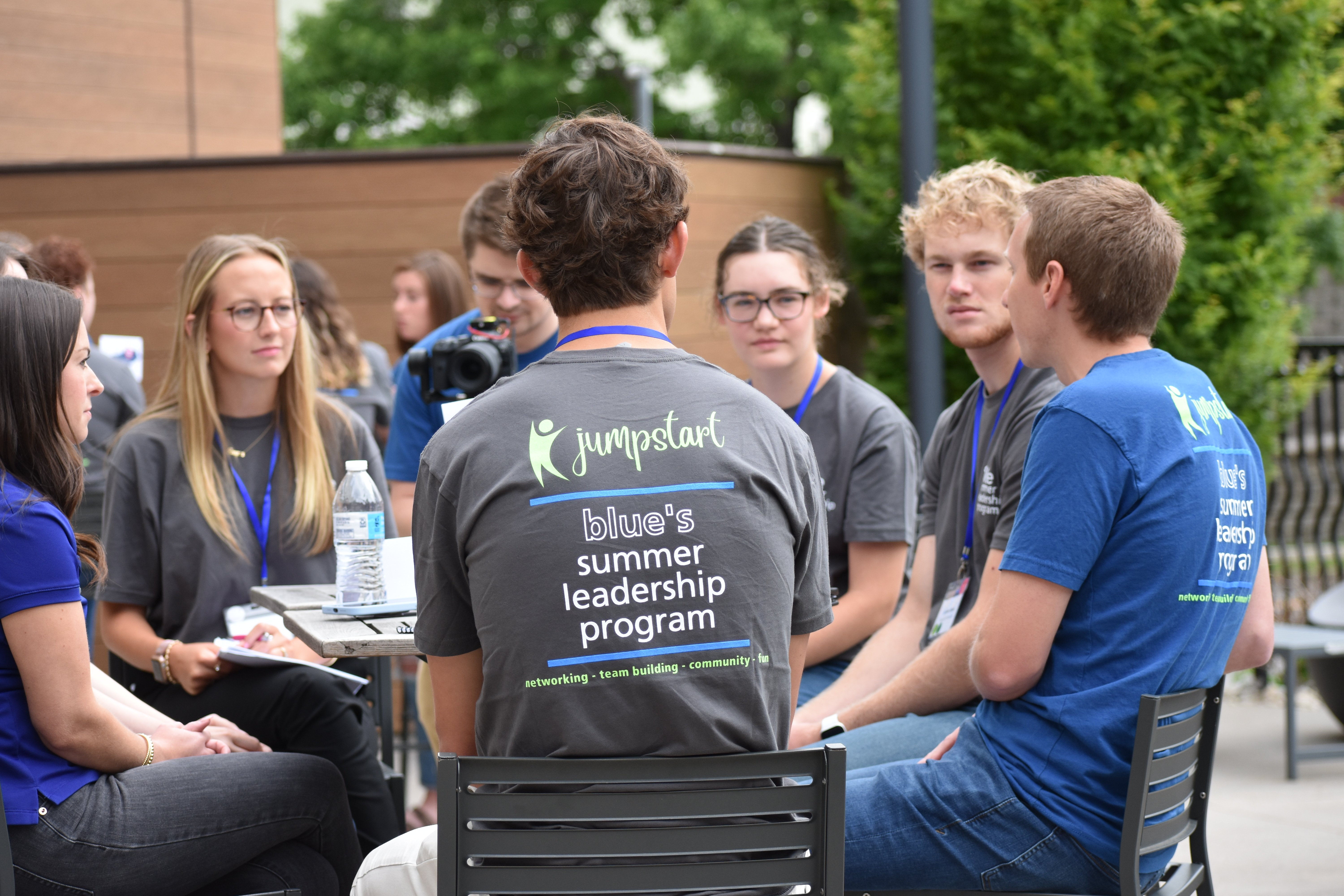 Students outside at table while in a breakout session at the Summer Leadership Program 2023