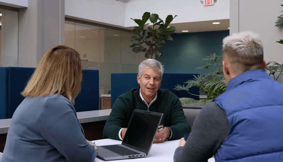 woman with laptop talking to two men at a table - video thumbnail